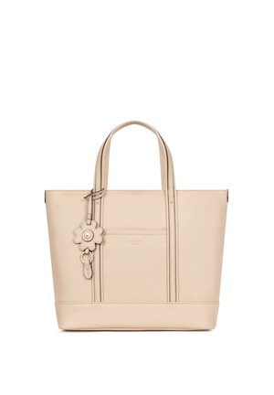 Borsa tote in pelle beige con doppi manici e portachiavi decorativo a forma di fiore sul davanti su sfondo bianco.