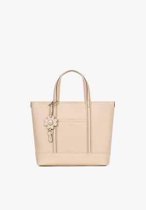 Sac fourre-tout en cuir beige avec double poignées et porte-clés décoratif en forme de fleur à l'avant sur fond blanc.