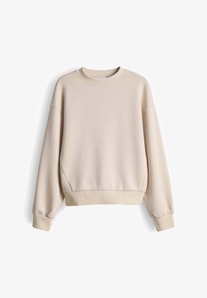Licht beige oversized sweatshirt met verlaagde schouders, geribbelde manchetten en zoom, gemaakt van zachte stof met een gladde structuur.