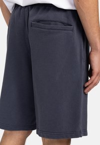 Navy blue cotton shorts with an elastic waistband, featuring a single back pocket and stitched hems for added durability.