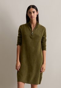 Olivgrünes Strickkleid mit Reißverschluss, das einen Stehkragen, lange Ärmel und einen lässigen Schnitt aufweist, mit gerippten Bündchen und Saum.
