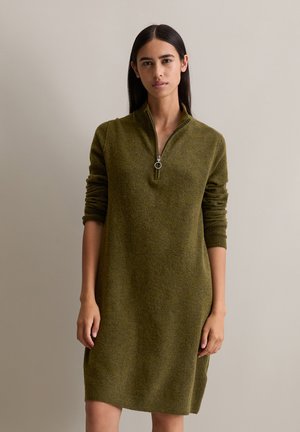 Abito a maglia verde oliva con zip, caratterizzato da un colletto alto, maniche lunghe e una vestibilità morbida, con polsini e orlo a costine.