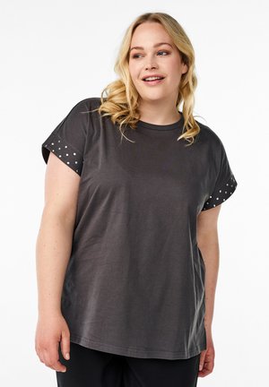 Donkergrijze T-shirt van katoen met korte mouwen. Mouwen hebben witte stippenaccenten. Relaxte pasvorm met een ronde hals.