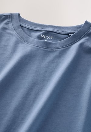 Blå bomulls-t-shirt med rund hals och korta ärmar. Texturerat tyg med en slät yta. Etiketten visar "NEXT" med storlek M.