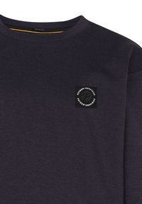 Felpa viola scuro con colletto rotondo, caratterizzata da un piccolo etichetta nera con un logo circolare sul petto. Realizzata in un morbido tessuto testurizzato.