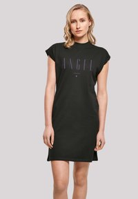 Schwarzes Baumwoll-T-Shirt-Kleid mit kurzen Ärmeln, das mit auffälligem, lila vertikal gedrucktem Text "ANGEL" und einem kleinen Stern-Detail darunter versehen ist.