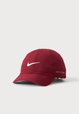 Czerwona czapka baseballowa Nike Dri-FIT ADV z perforowanymi otworami wentylacyjnymi i białym logo Nike na przedzie.