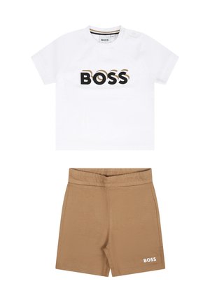 T-shirt bianca a maniche corte con logo "BOSS" in nero e oro, abbinata a pantaloni beige con vita elastica e accento "BOSS" bianco.