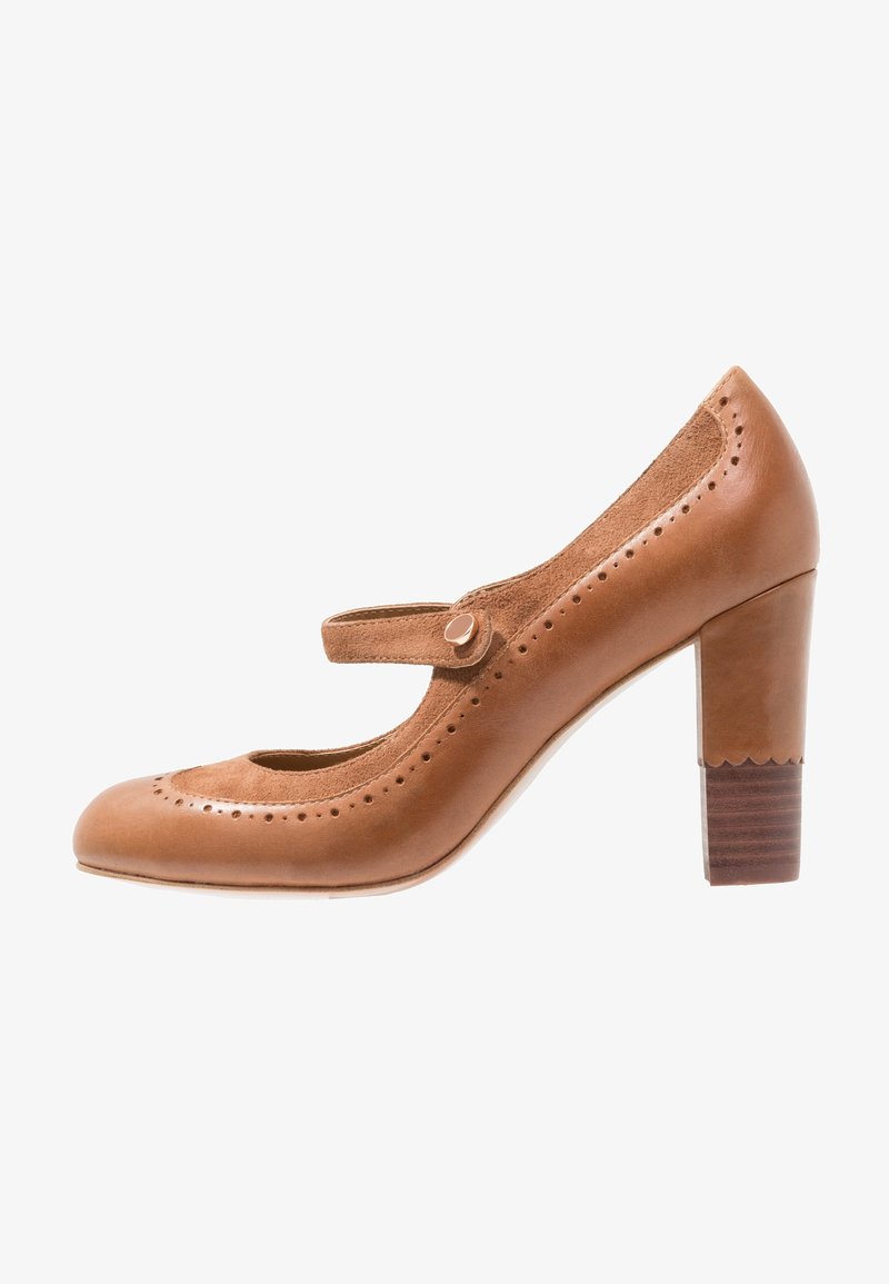Chaussure Mary Jane en cuir et daim marron avec des détails perforés et un talon moyen épais, vue de profil latéral sur fond blanc.