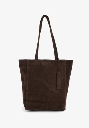 Sac cabas en daim marron foncé avec deux longues anses et une étiquette rectangulaire suspendue à une anse.