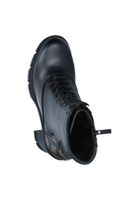 Bottine en cuir noir avec un laçage sur le devant, panneau latéral texturé arborant un motif subtil, et une semelle épaisse.