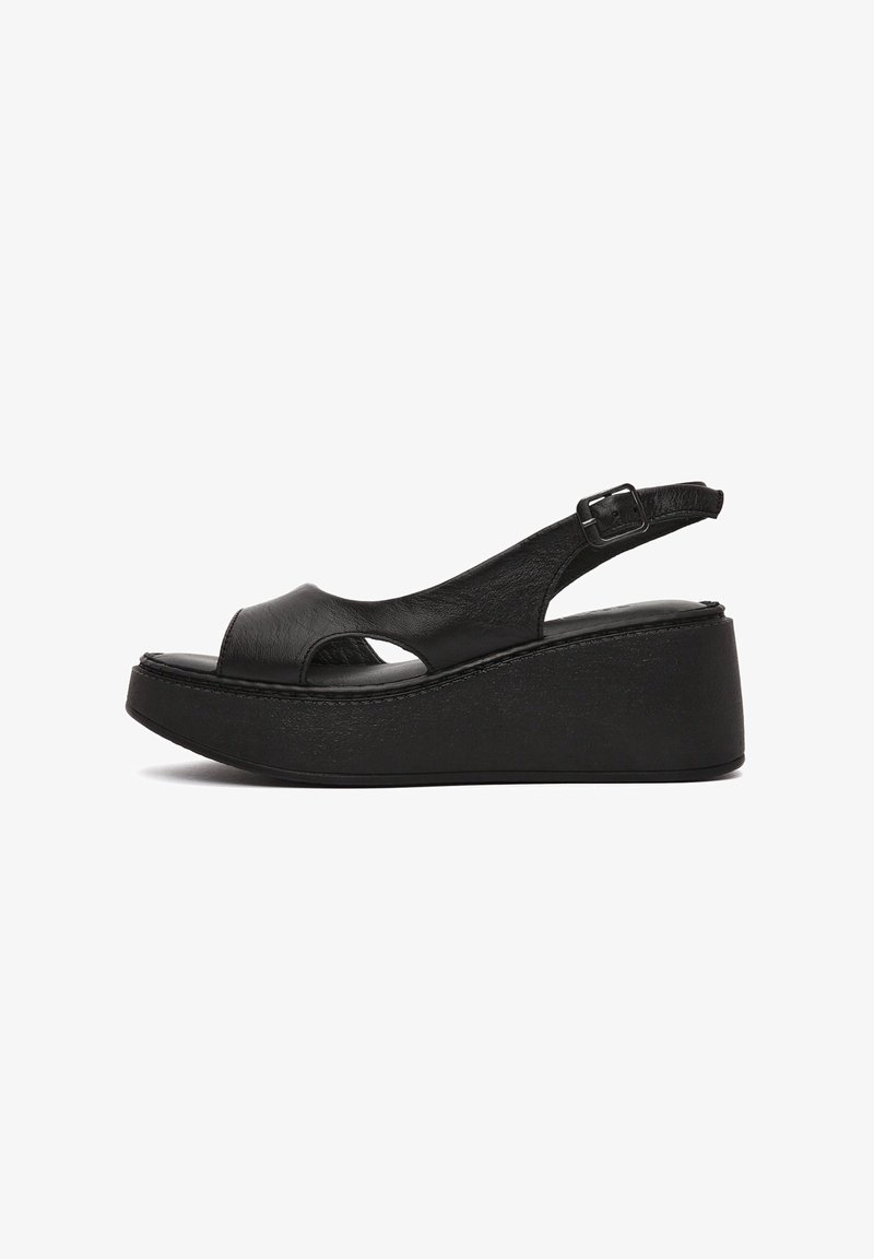 Sandale compensée noire avec bout ouvert, bride de cheville réglable avec boucle, et semelle plateforme épaisse.