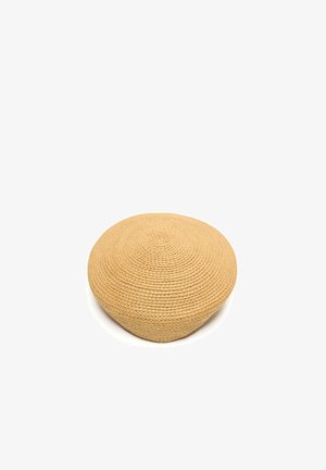 Cappello rotondo beige in paglia intrecciata con cima piatta e senza tesa visibile su sfondo bianco.