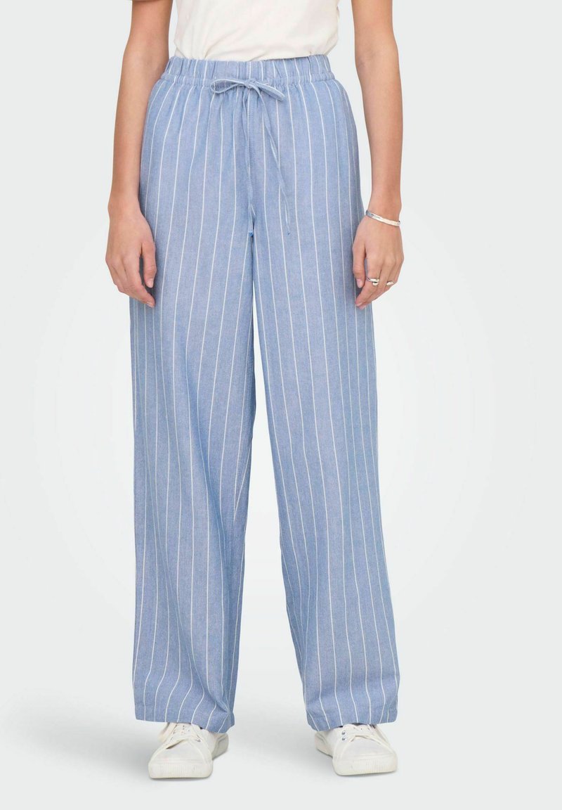 Hele sinised, laia lõikega püksid, millel on vertikaalsed valged triibud, elastne vöökoht ja reguleeritav pael. Valmistatud pehmest, hingavast kangast.