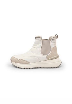 Botines beige y blancos con una parte superior de textil y ante, paneles laterales elásticos, suela de goma y una lengüeta en el talón para ponerlos con facilidad.