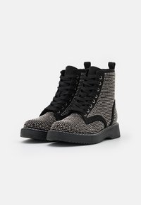 Black ankle boots with a studded texture, featuring a lace-up design, a padded collar, and a rubber sole for traction.