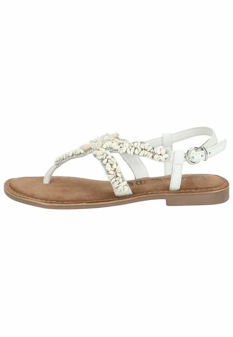 Sandales thong blanches avec des accents de coquillage décoratifs, semelle intérieure texturée marron et semelle plate. Bride de cheville ajustable avec détail de boucle.
