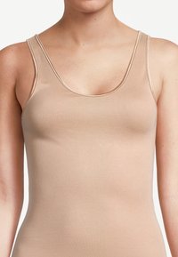 Canotta nuda con spalline sottili, realizzata in tessuto morbido e elasticizzato. Presenta un scollatura arrotondata e un design aderente.