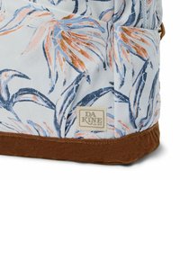 Backpack features a light blue fabric with a floral pattern in orange and blue, accented by a brown base and a DA KINE logo patch.