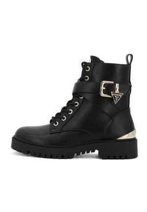 Bottine noire en cuir avec lacets, semelle épaisse, bride à boucle sur le côté et pendentif logo métallique Guess USA sur le talon.