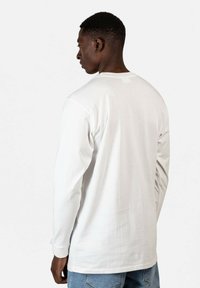 Weißes Langarm-T-Shirt aus Baumwolle, mit einem schlichten Design, Rundhalsausschnitt und legerem Schnitt. Glatte Textur und minimale Details.