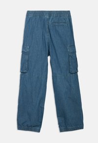 Τζην cargo παντελόνι σε μεσαίο μπλε χρώμα, με ελαστική μέση, πλαϊνές τσέπες και ελαστικές μανσέτες στους αστραγάλους.