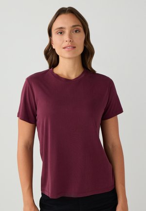 Bordeaux T-shirt met korte mouwen van zachte, lichte stof. Beschikt over een klassieke ronde hals en een relaxte pasvorm. Geen zichtbare patronen.