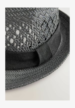 Must mustrõng mustra, millel on lai äär, mustast kootud sõfalat, mustast kangast vöö baasi ümber. Avatud kudumis muster lähedal kroon.