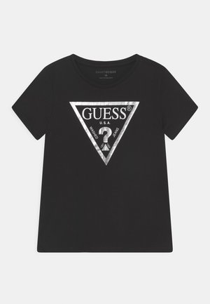 Sort t-shirt med korte ærmer med sølvmetallisk Guess trekant-logo og teksten "GUESS U.S.A. Washed Jeans" foran.