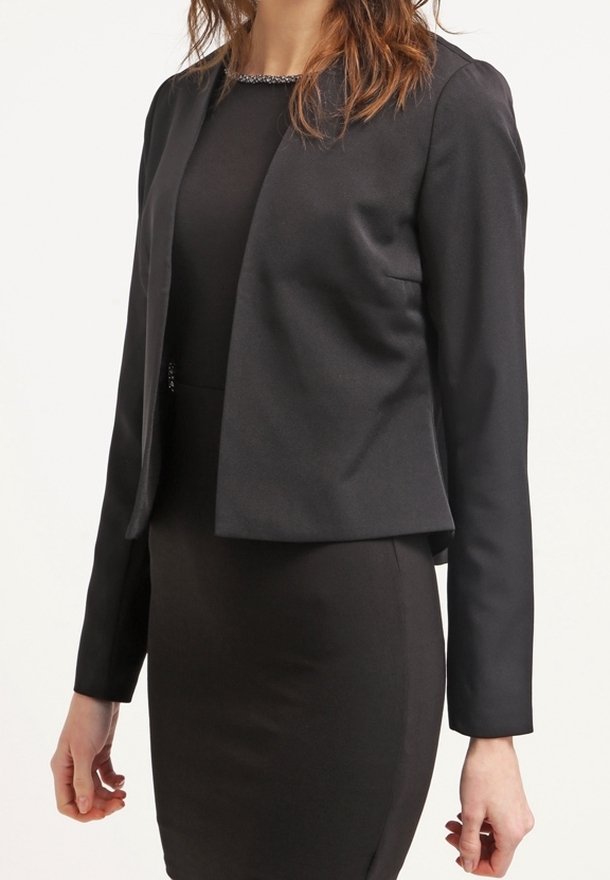 Svart kort blazer i slätt tyg, med rund halsringning och långa ärmar, kombinerad med en åtsittande svart klänning.