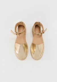 Gouden metallic espadrille sandalen met een bandje, geweven jute zool en een soepele teenkap. Ontblootte enkel en zachte leren interieur.