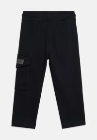 Μαύρο cropped παντελόνι φόρμας με ελαστική μέση και τσέπη cargo με καπάκι και κουμπί με κλειδώστρα στο αριστερό πόδι.