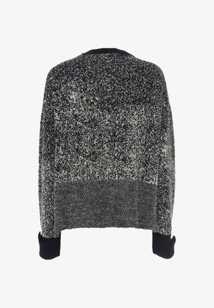 Maglione lavorato a maglia bianco e nero, design squadrato, polsini a coste, motivo texturizzato, vista posteriore che mostra stili di lavoro a maglia e colori variati.