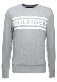 Felpa grigia a maniche lunghe con colletto tondo, caratterizzata da strisce orizzontali bianche e testo "HILFIGER" sul petto.