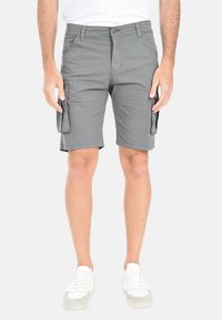 Pantaloni cargo grigi in misto cotone, con tasche laterali, chiusura a bottone e vestibilità comoda, abbinati a sneakers bianche.
