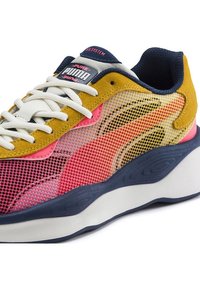 Baskets Puma avec une tige en mesh jaune, rose et marine, agrémentée d'accentuations en daim ; semelle épaisse blanche et marine ; logo sur la languette.