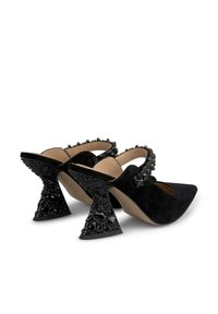 Scarpe in suede nere con punta affusolata e design ritagliato. Presentano dettagli gioiello su tacchi neri scolpiti e texture.