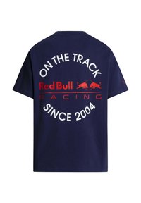 Μπλε ναυτικό μπλουζάκι με κόκκινο και λευκό κείμενο «Red Bull Racing On the Track Since 2004» και δύο λογότυπα κόκκινων ταύρων στην πλάτη.