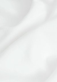 Tessuto bianco con una consistenza liscia e morbida, che presenta pieghe e grinze naturali. Il materiale appare leggero e uniforme nel colore.