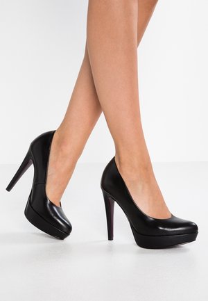 Zwarte hoge hakken met een glanzende leren afwerking, ronde neus en een platformontwerp. Voorzien van een slanke stilettohak en subtiele paarse accenten.