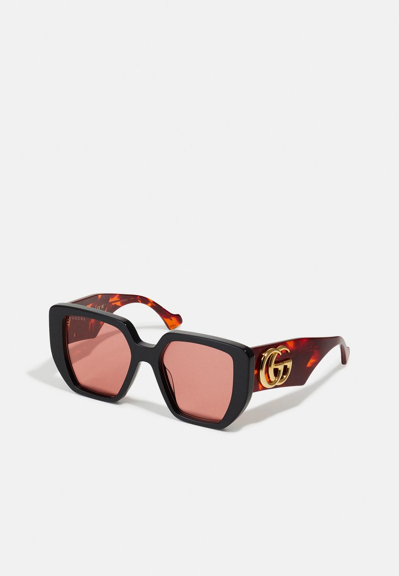 Oversized zonnebrillen met zwarte plastic monturen, roze lenzen en armen met schildpadpatroon, voorzien van een gouden dubbele-G logo.