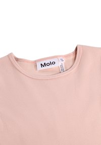 Svijetloružasti rebrasti gornji dio s okruglim izrezom i oznakom "Molo" pričvršćenom unutra. Lagano teksturirana površina, ležerni dizajn.