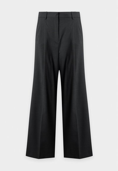 Pantalon noir à jambes larges avec passants de ceinture, pli sur le devant et taille haute sur un fond clair uni.