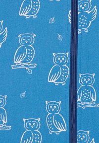 Tessuto blu con illustrazioni di gufi bianchi e motivi di foglie, con una zip centrale di un blu scuro. La texture appare liscia e leggera.