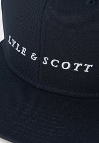 Black fabric cap with white embroidered text "LYLE & SCOTT" on the front panel above the brim.
