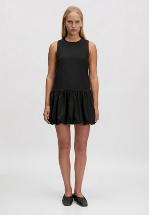 Schwarzes Kleid mit ärmellosem Design, das oben glatt und unten mit einem gerafften, ballonartigen Saum gestaltet ist. Hergestellt aus leichtem Stoff mit einem glänzenden Finish.