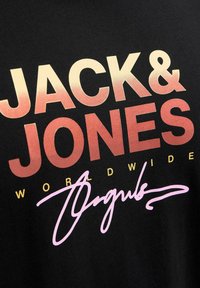 Juodas medvilninis marškinėliai su gradientiniu logotipu "JACK & JONES" nuo auksinės iki rožinės spalvos, su "WORLDWIDE" geltona spalva ir rožinėmis akcentu.