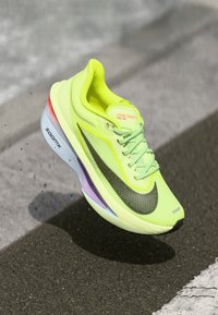 Nike Zoom Fly 06 running shoe, bright yellow mesh upper, black swoosh, colorful gradient midsole, lightweight design, raised heel.