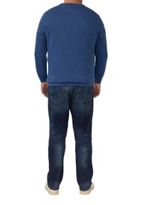 Herren Sweatshirt in Blau mit rundem Halsausschnitt und langen Ärmeln, kombiniert mit dunkelblauen Jeans im Used-Look und zwei Gesäßtaschen.