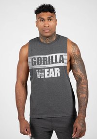 Grijze mouwloze shirt met een gedurfde "GORILLA WEAR" grafiek in wit en zwart. Zachte stof, ontspannen pasvorm, ideaal voor atletische activiteiten.
